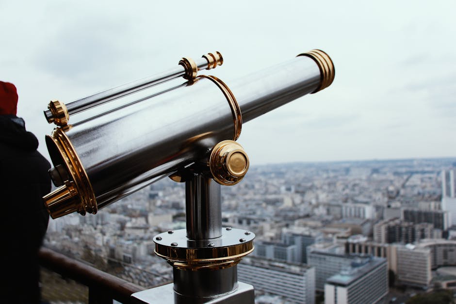 Coin-operated telescope overlooking the Paris cityscape from a high vantage point.