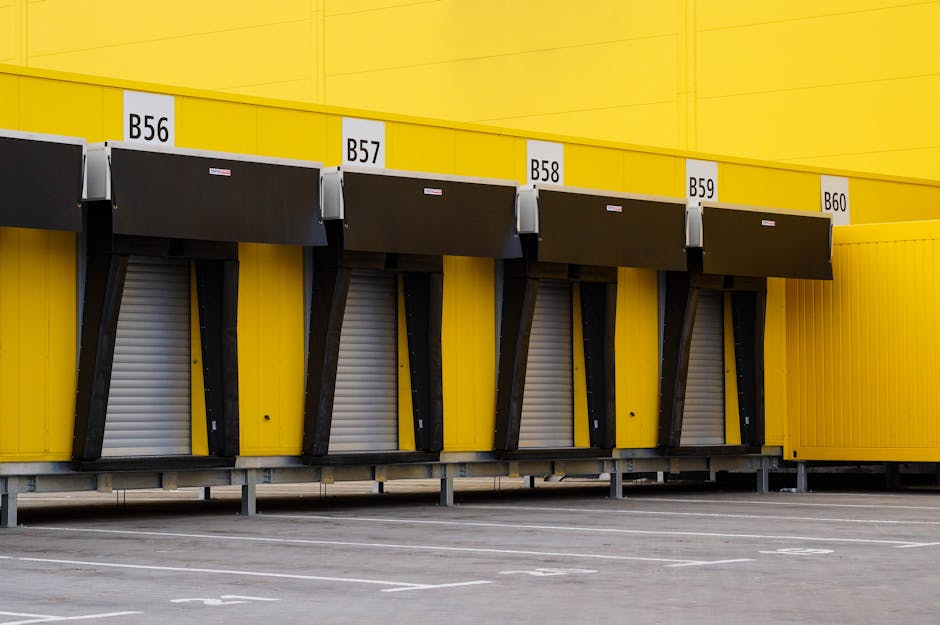 Industrial loading bays with vibrant yellow walls and closed doors.