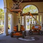 Construction lifts under architectural arches, showcasing urban renovation efforts.