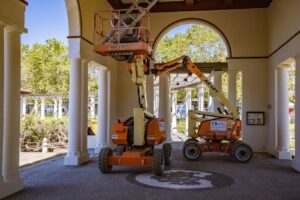 Construction lifts under architectural arches, showcasing urban renovation efforts.