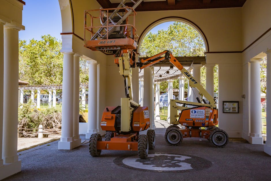 Construction lifts under architectural arches, showcasing urban renovation efforts.